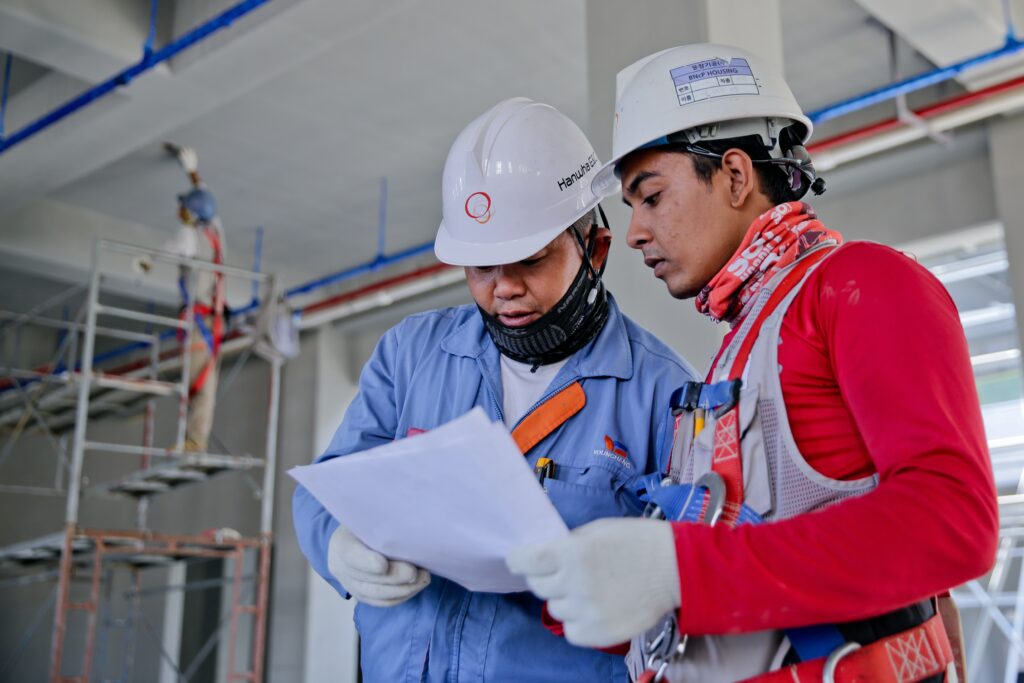 Two men discussing compliance at a factory