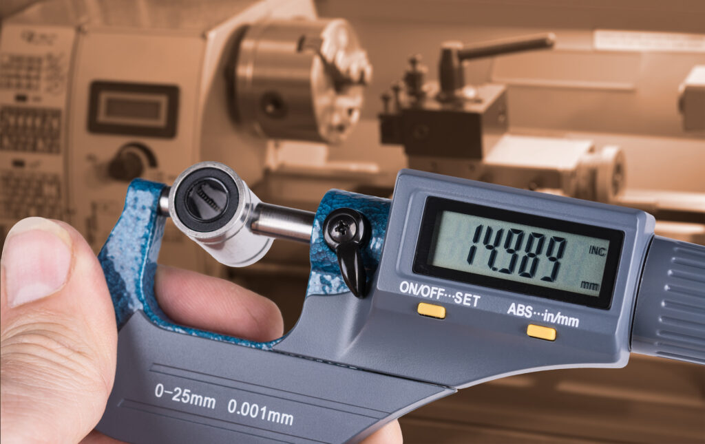 Detail of skilled worker's hand with digital micrometer screw gauge