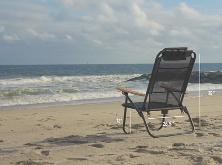 Black mesh beach chair sitting in the sand on a sunny beach day