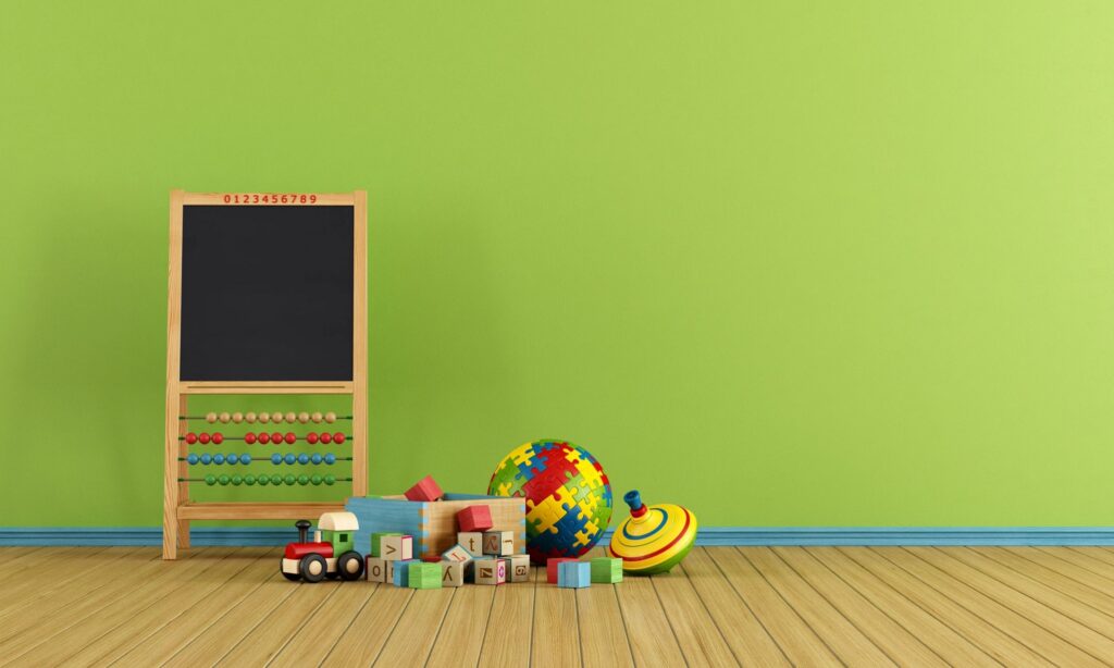 Children's toys in front of a green wall